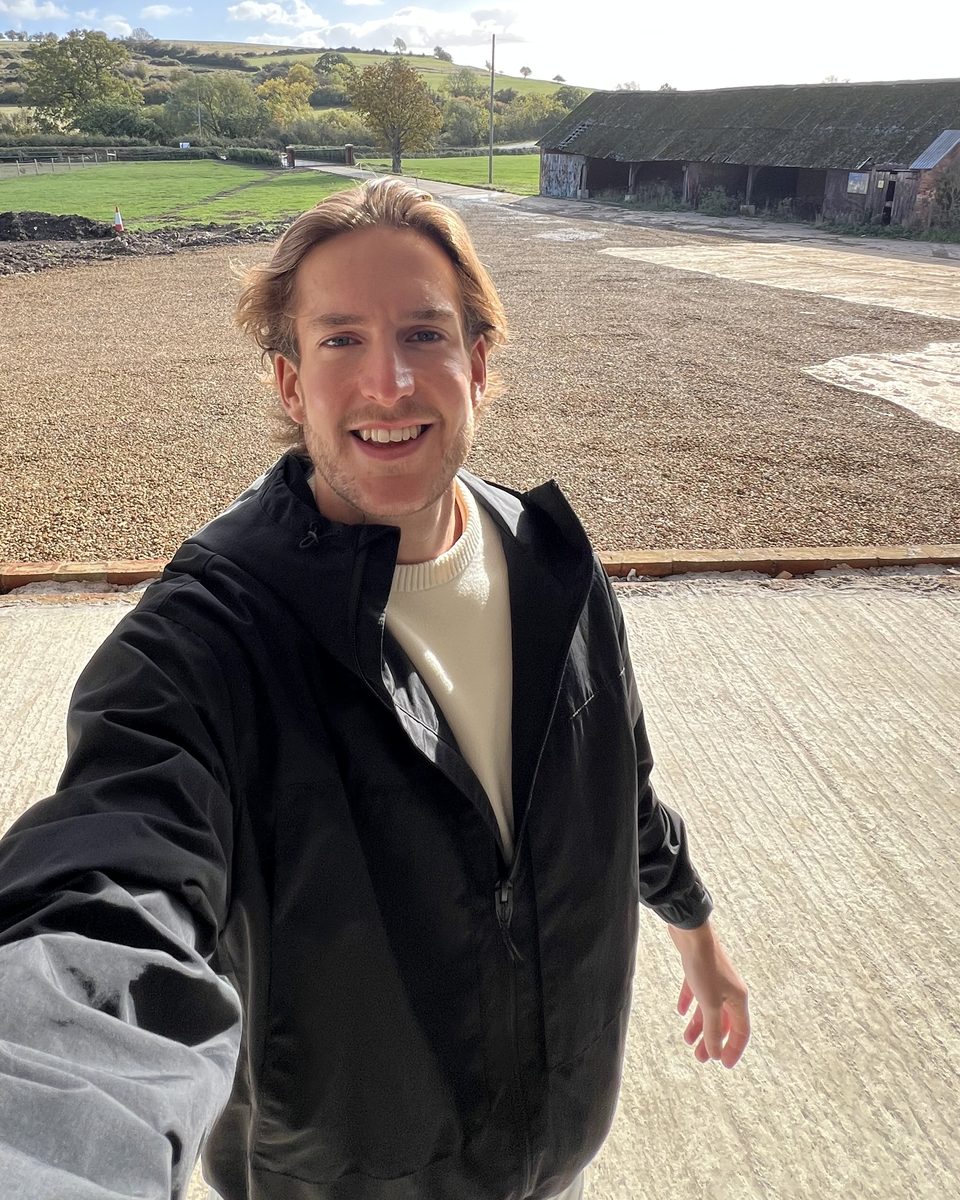 Josh smiling outside the barn at Oakcroft Farm
